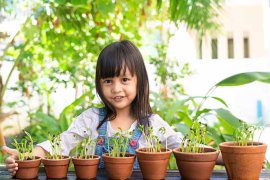 little girl with pots of vegetables