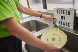 Food vendor washing reusable plate at an event