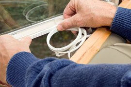 Home owner sealing their windows for energy efficiency