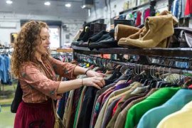 Female shoppng and searching through clothes rack