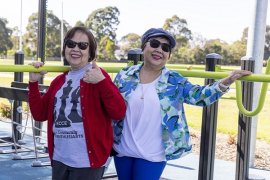 Two people outdoors smiling at the camera 