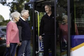 Two people boarding the Community Transport Bus