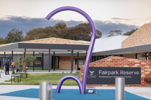 Front entrance of the renovated Fairpark Reserve with a purple metal sculpture shaped like a shepard's staff in the foreground