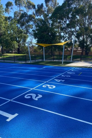 Blue athletics track and yellow sunshade